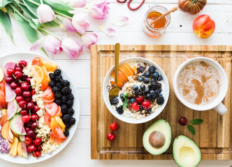 A breakfast bowl with oats, berries, walnuts, and a glass of water on a sunlit kitchen table.