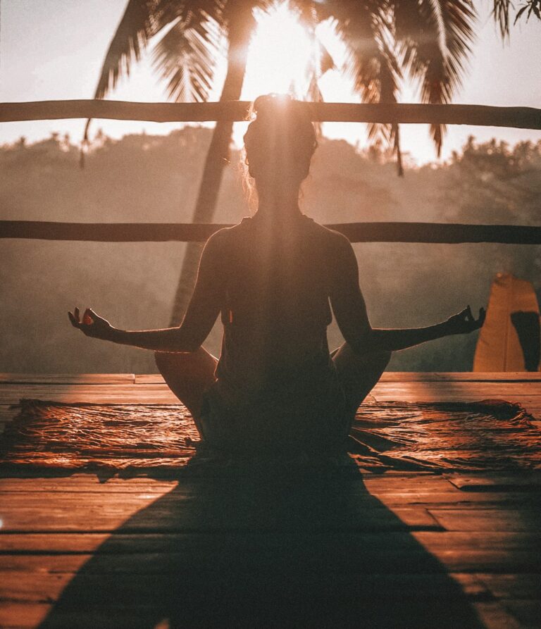 A diverse group of people sitting comfortably and meditating together in a sunlit living room.